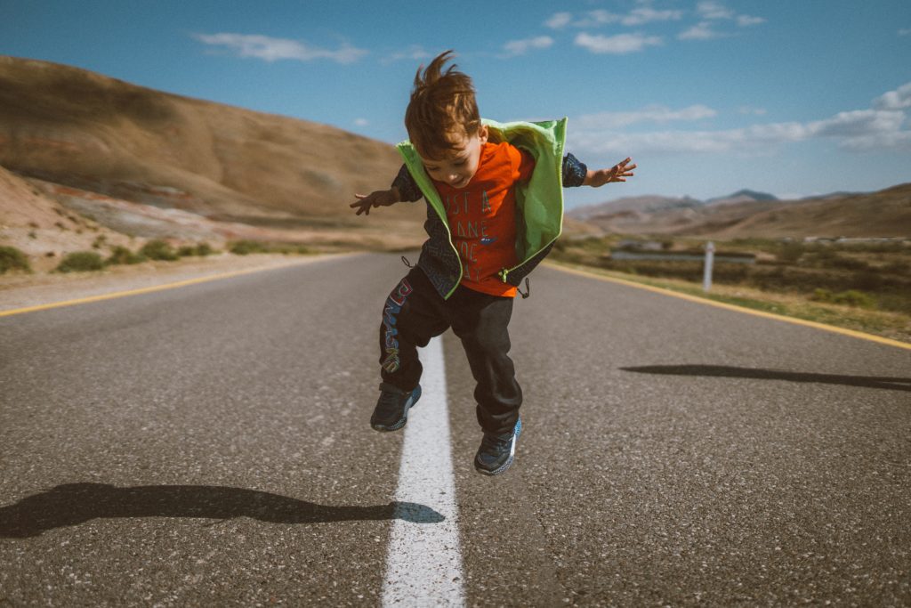 child jumping in the road